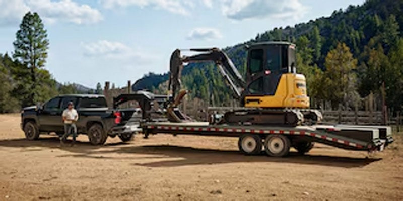 2026 Chevrolet Silverado 2500HD towing an excavator on a gooseneck trailer