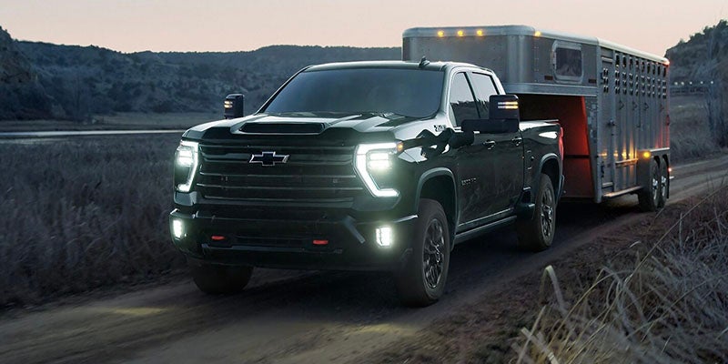 2026 Chevrolet Silverado 2500HD towing a livestock trailer at dusk